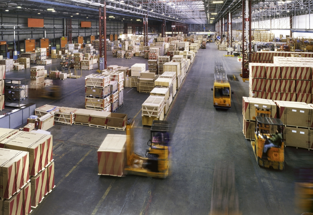 Professional movers handling heavy machinery in a warehouse for an industrial move by Abwini Transportation Services